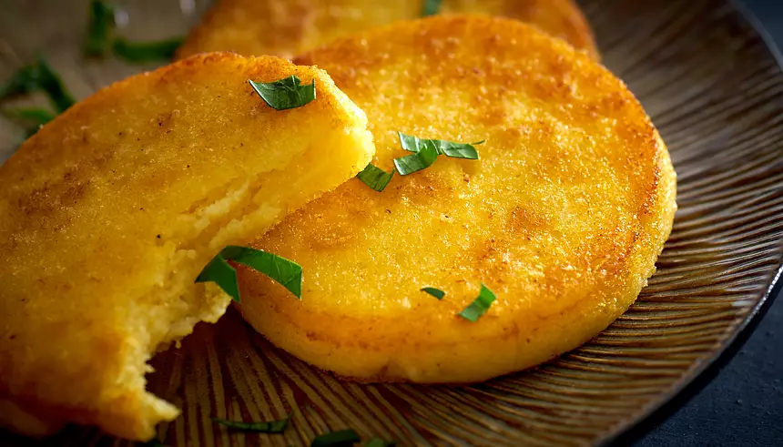 Close-up of golden polenta with thinly sliced parsley. 